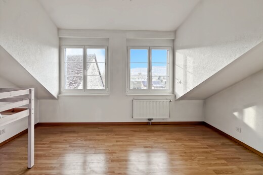 pièce vide avec vaulted ceiling, plafond voûté, radiateur, wood finish floor, et sol en finition bois