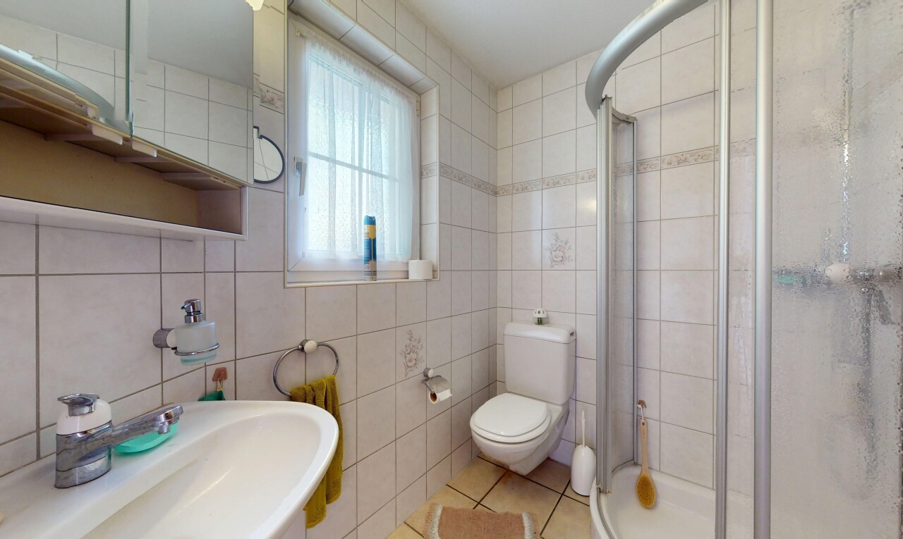 salle de bains avec inside property, natural light, lumière naturelle, tile wall, et mur en carrelage