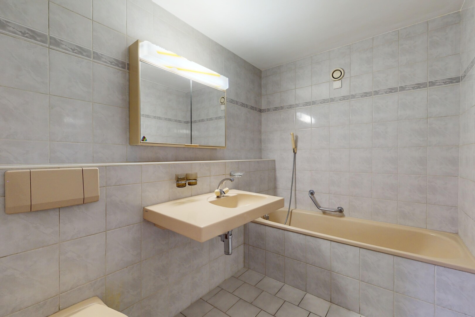 salle de bains avec miroir, mur carrelé, vasque, et baignoire