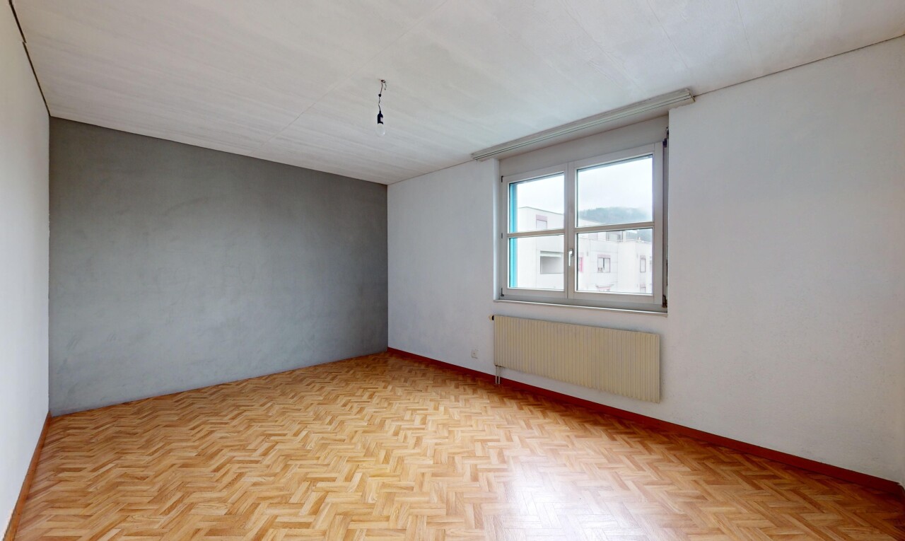 pièce vide avec lumière naturelle, radiateur, et parquet