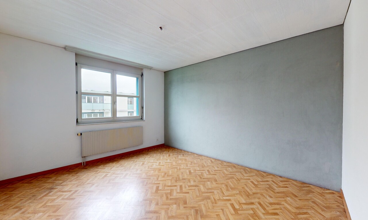 pièce vide avec parquet, radiateur, et lumière naturelle