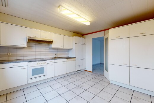 cuisine avec carrelage, four, hotte, crédence, et meubles blancs