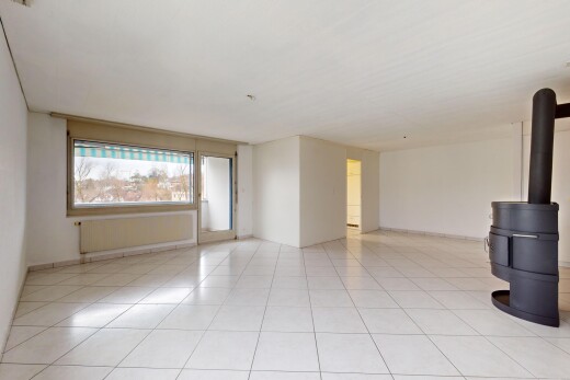 leerer raum mit fliesenboden, natürliches licht, holzofen, und kühler