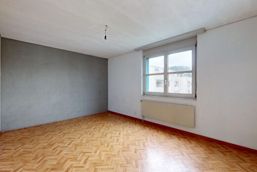 pièce vide avec lumière naturelle, radiateur, et parquet