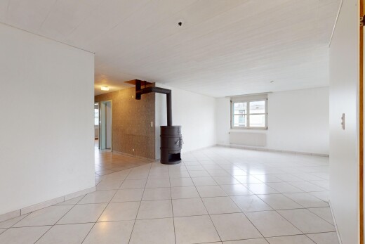 leerer raum mit fliesenboden, natürliches licht, und holzofen