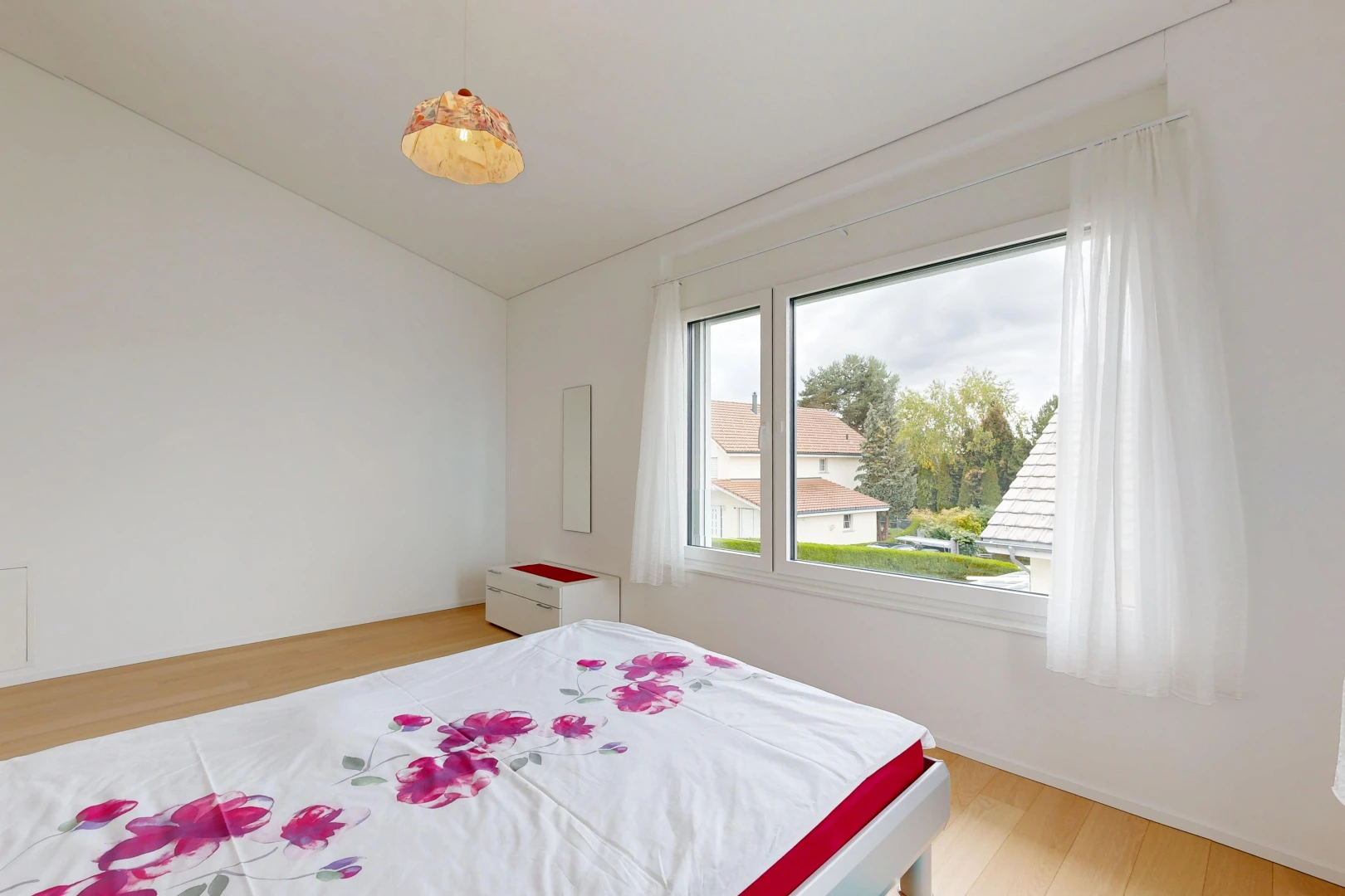 zimmer / schlafzimmer mit wood finish floor, holzfußboden, pendelleuchte, drywall, und gipskartonwand