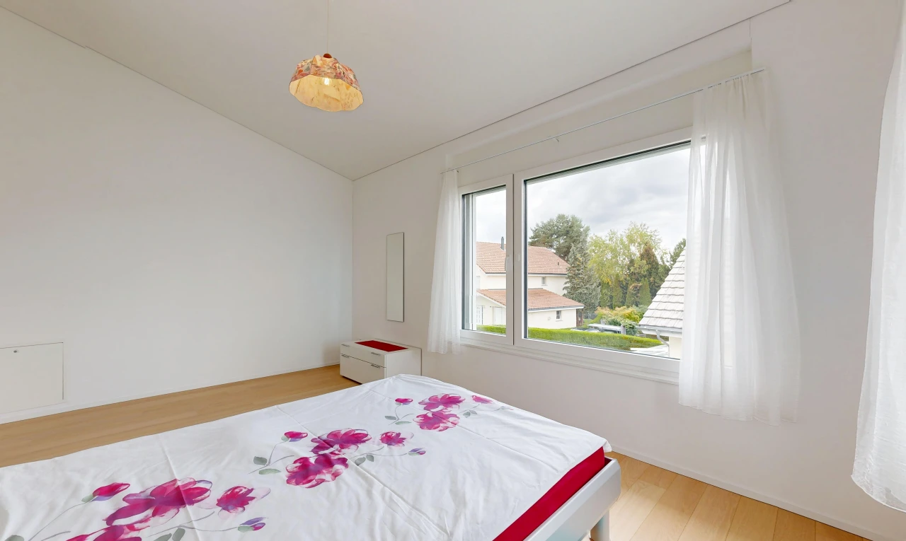 zimmer / schlafzimmer mit wood finish floor, holzfußboden, pendelleuchte, drywall, und gipskartonwand