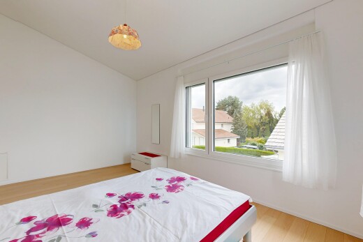 zimmer / schlafzimmer mit wood finish floor, holzfußboden, pendelleuchte, drywall, und gipskartonwand