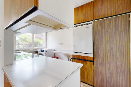 kitchen featuring light countertops, wood finish cabinets, a peninsula, and washing machine and clothes dryer