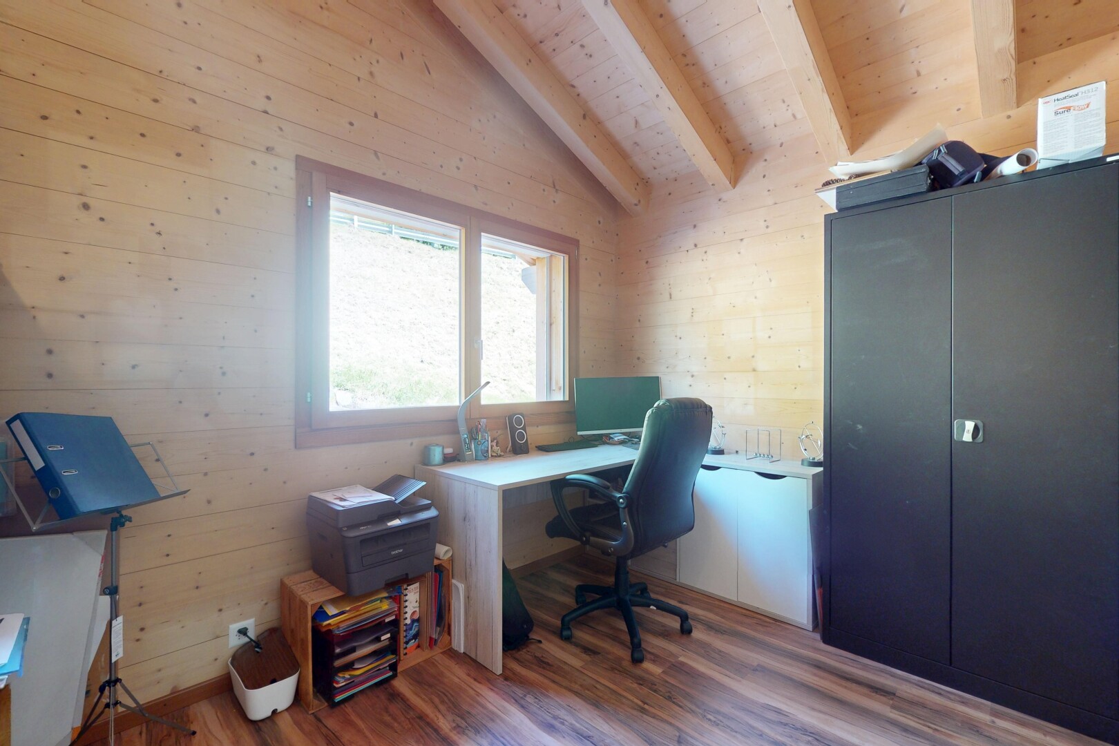 bureau avec télévision, mur en bois, wood wall, plafond voûté, et vaulted ceiling