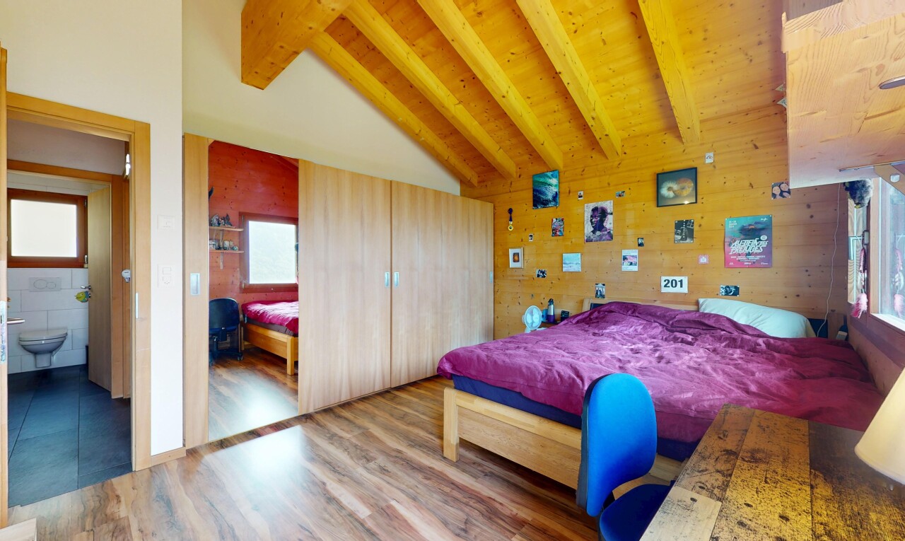 chambre avec vaulted ceiling, plafond voûté, wood finish floor, sol en finition bois, et beamed ceiling