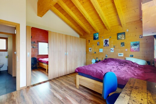 chambre avec vaulted ceiling, plafond voûté, wood finish floor, sol en finition bois, et beamed ceiling