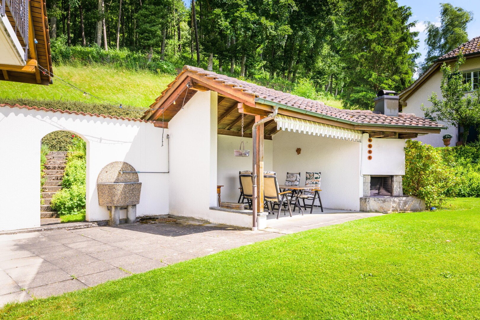 außenansicht mit terrasse, kamin, stuckverkleidung, property visible, und rasen