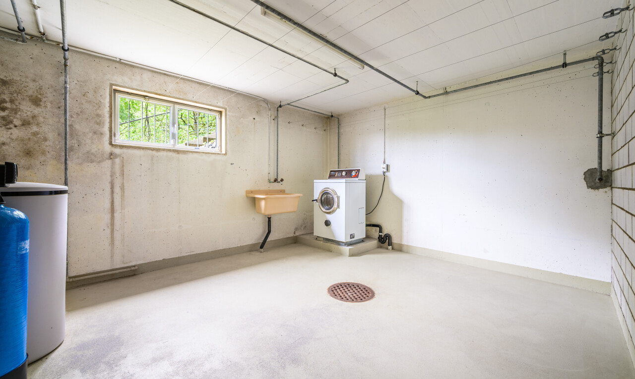 wäschekammer mit tumbler, natürliches licht, natural light, inside property, und concrete floor