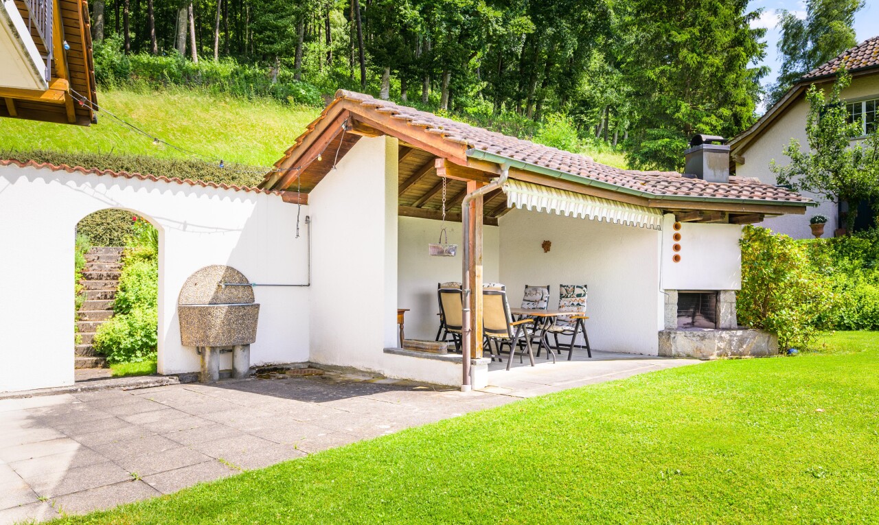 außenansicht mit terrasse, kamin, stuckverkleidung, property visible, und rasen
