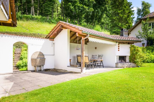 außenansicht mit terrasse, kamin, stuckverkleidung, property visible, und rasen
