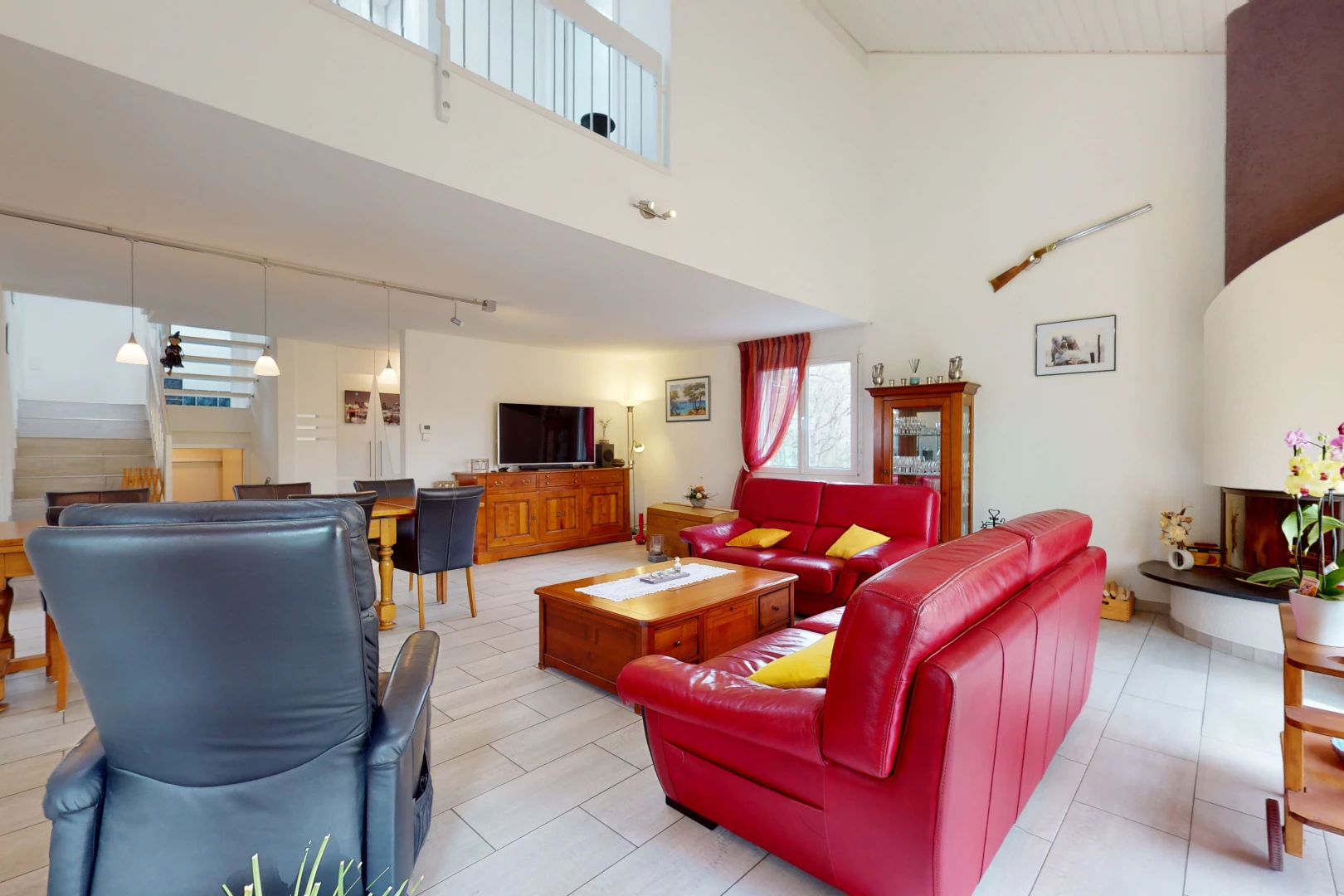 salon avec haut plafond, carrelage, et télévision