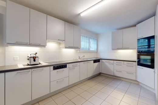 cuisine avec lumière naturelle, carrelage, four, cuisinière électrique, sol clair, et meubles blancs