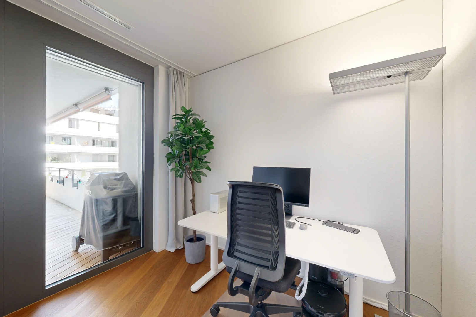bureau avec plancher de bois, télévision, et lumière naturelle