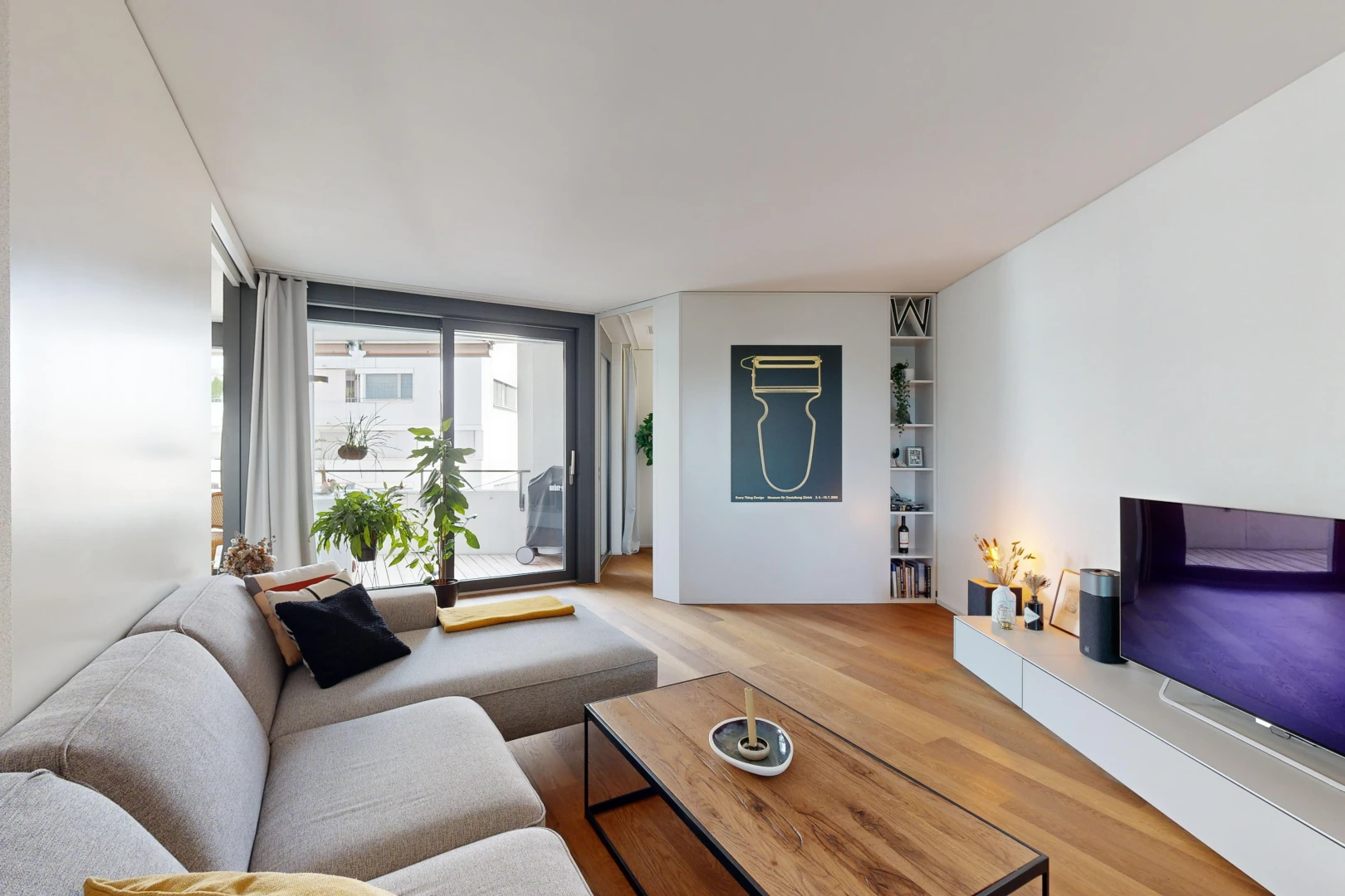 salon avec plancher de bois, télévision, et lumière naturelle