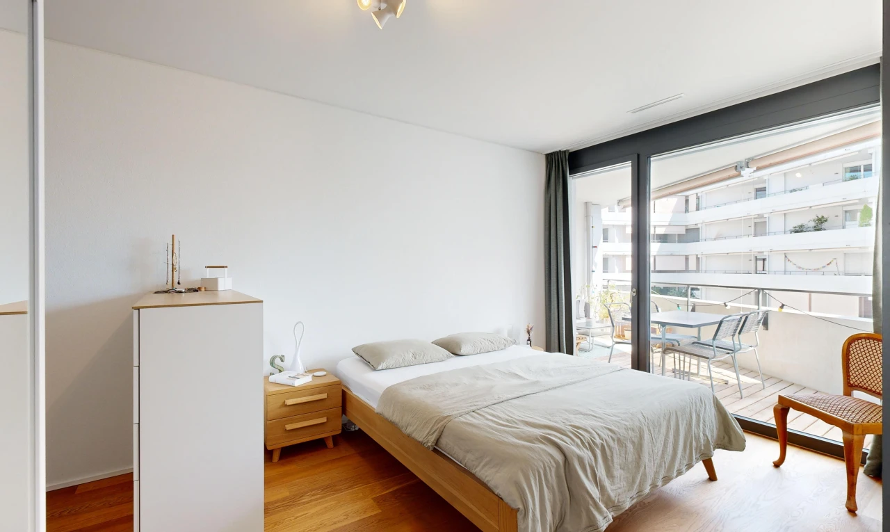 chambre avec plancher de bois et lumière naturelle