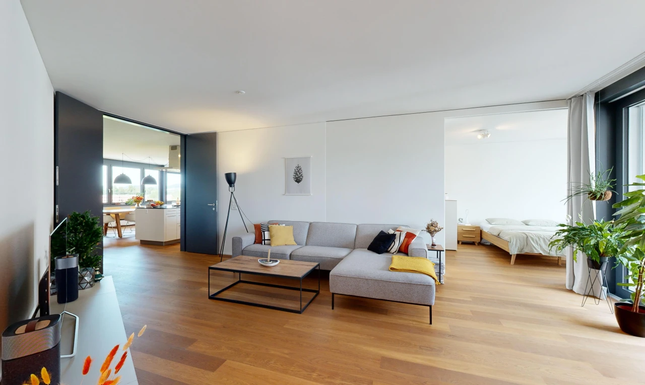 salon avec fenêtres du sol au plafond, plancher de bois, et lumière naturelle