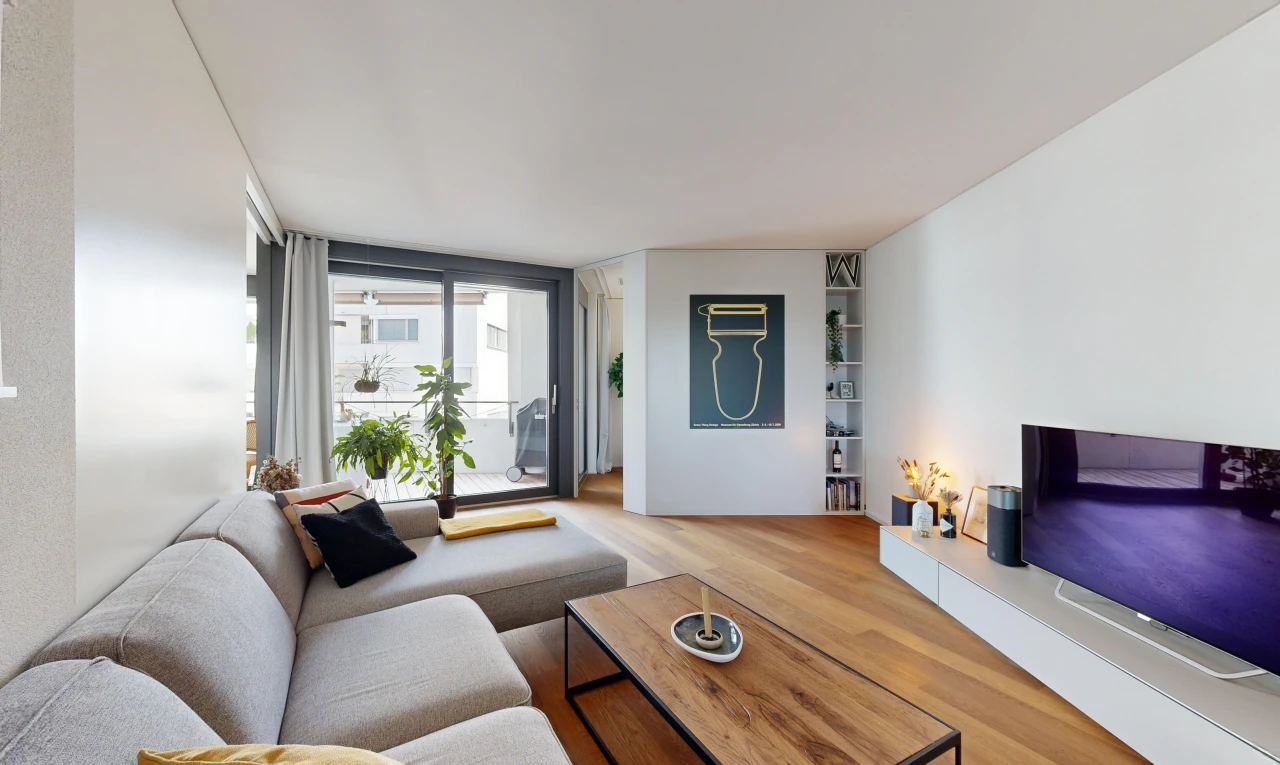 salon avec plancher de bois, télévision, et lumière naturelle