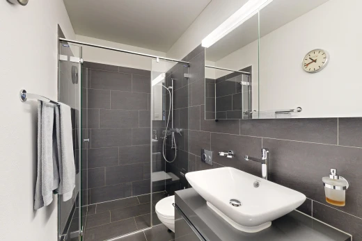 bad mit küchenrückwand beim herd, waschbecken, toilette, spiegel, und fliesenwand