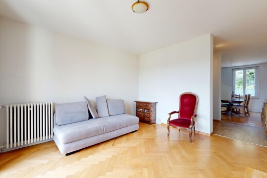 salon avec radiateur, wood finish floor, sol en finition bois, drywall, et cloison sèche