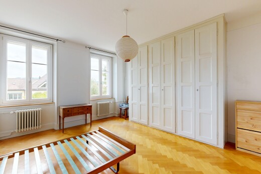 chambre avec radiateur, éclairage suspendu, drywall, cloison sèche, et wood finish floor