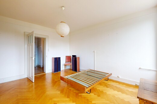 chambre avec drywall, cloison sèche, wood finish floor, sol en finition bois, et éclairage suspendu