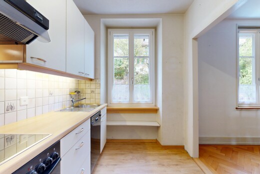 cuisine avec hotte, sol en finition bois, wood finish floor, plans de travail, et light countertops
