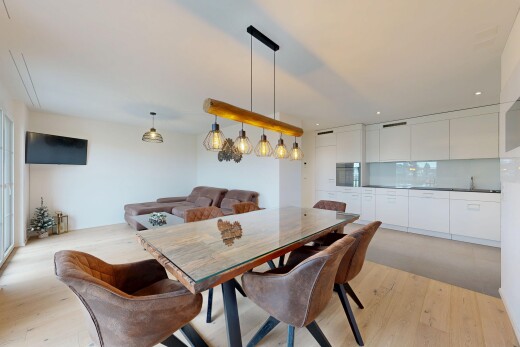 salle à manger avec télévision, cloison sèche, drywall, sol en finition bois, et wood finish floor