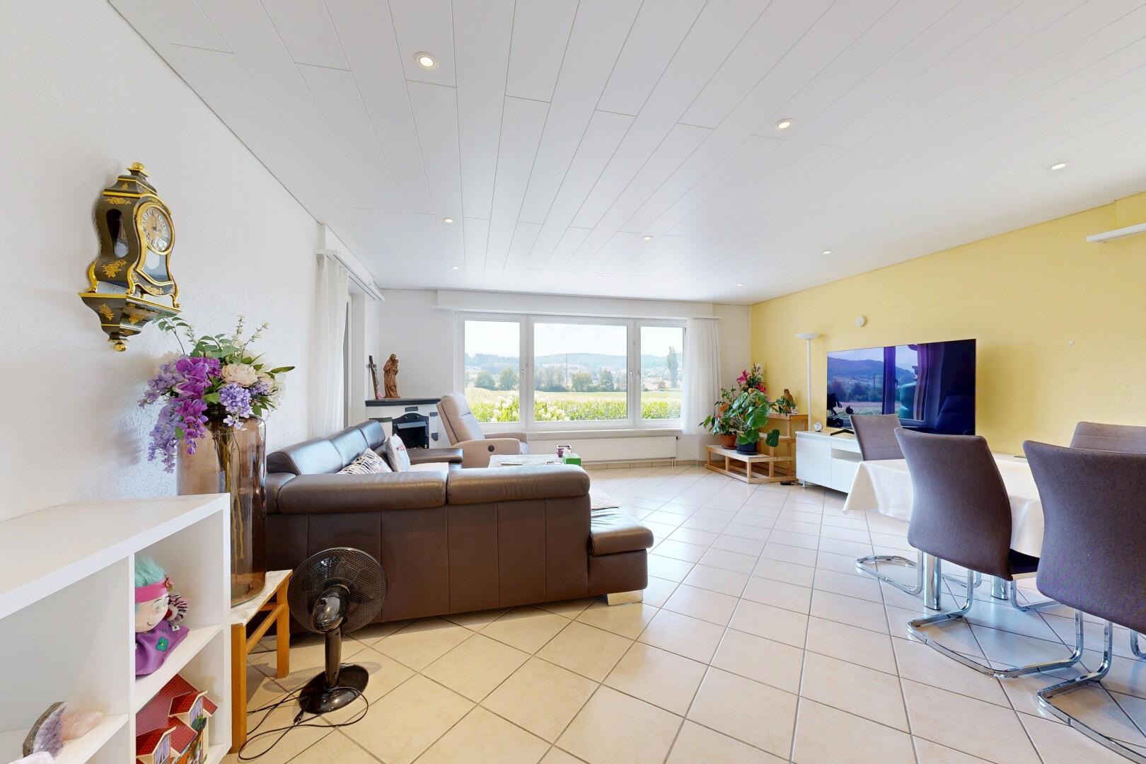 wohn- / esszimmer mit fernseher, einbauleuchten, drywall, gipskartonwand, und tile floor