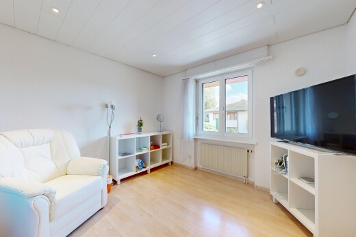 salon avec télévision, radiateur, wood finish floor, sol en finition bois, et éclairage encastré