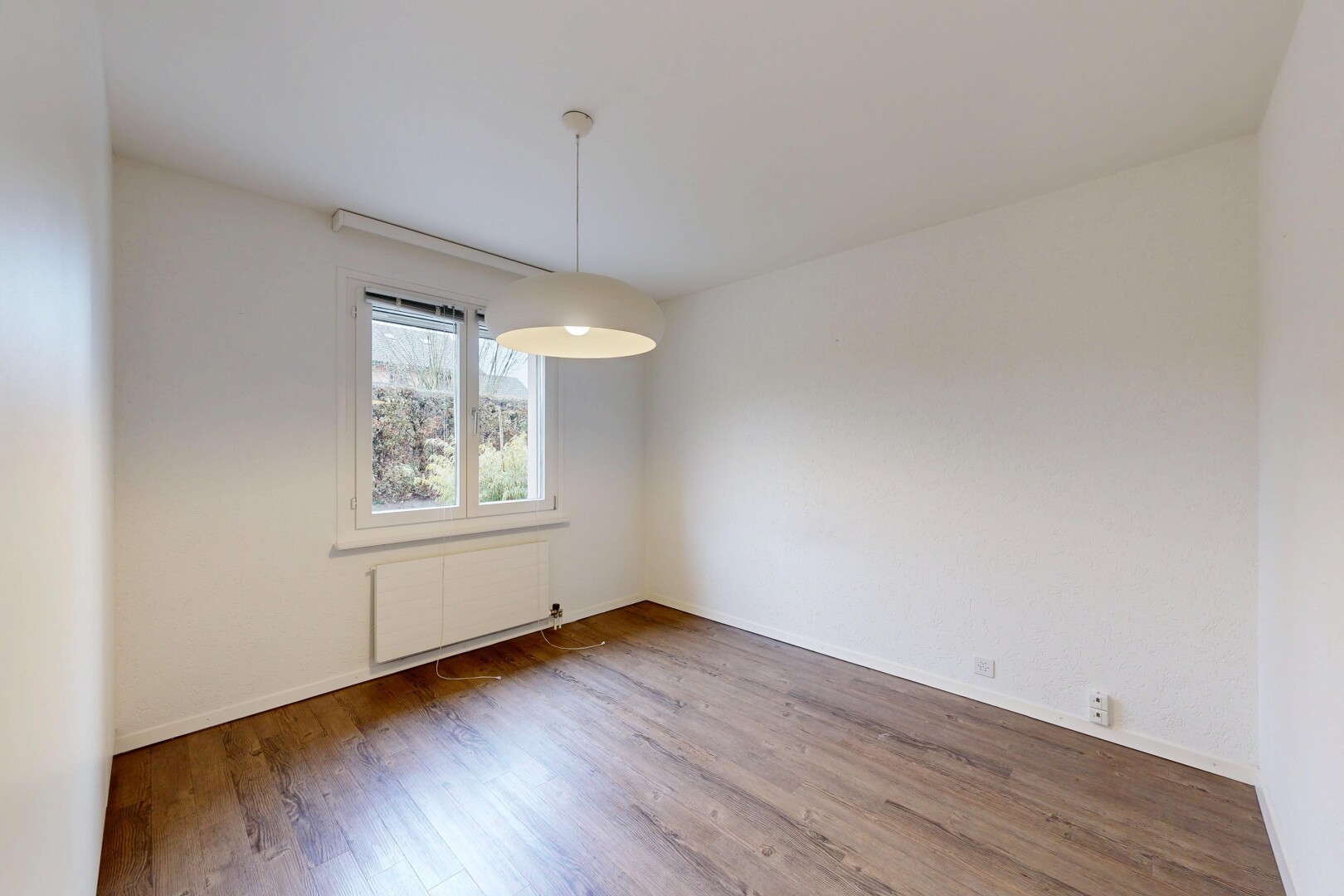 pièce vide avec inside property, natural light, lumière naturelle, radiateur, et wood finish floor