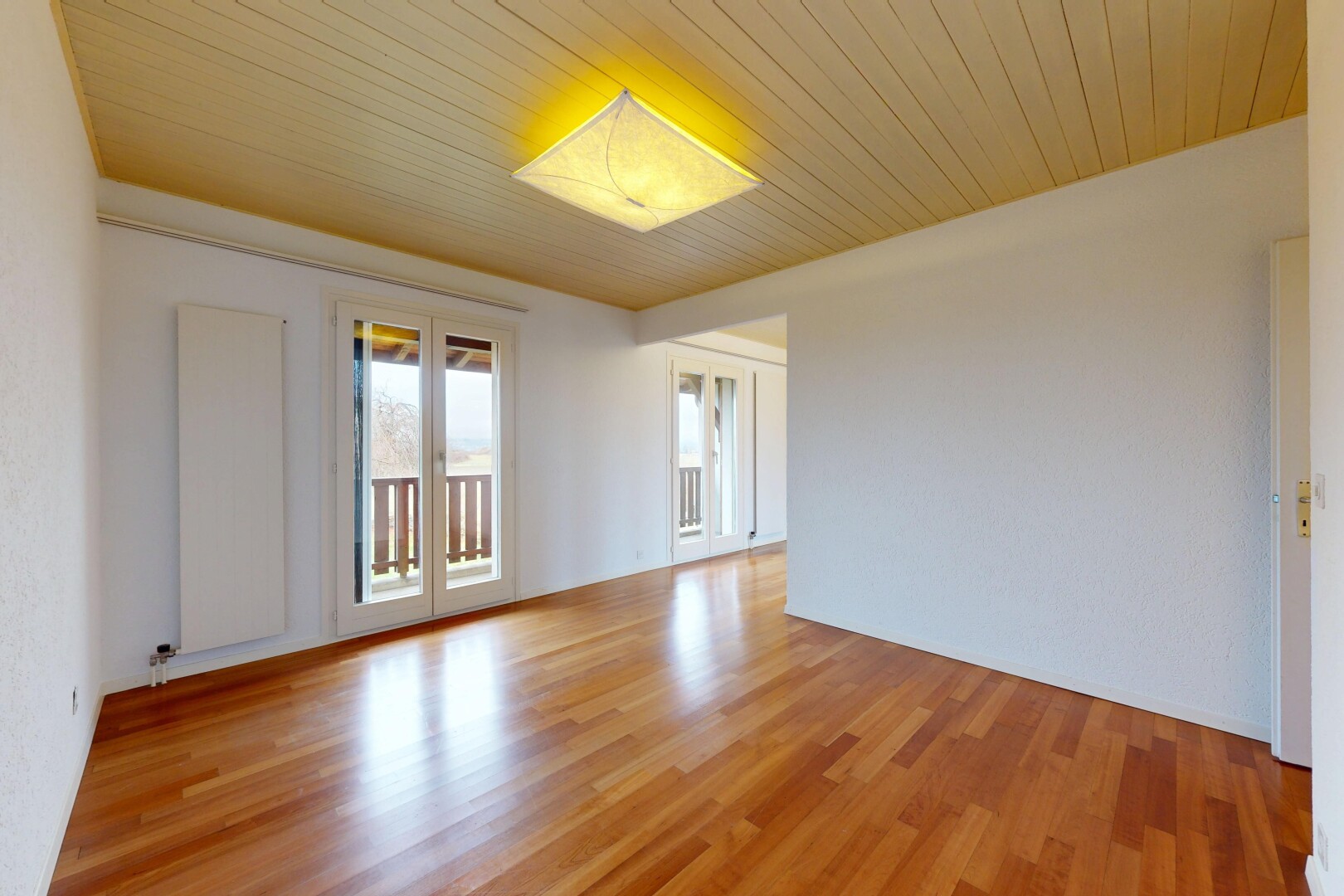 pièce vide avec inside property, natural light, lumière naturelle, wood finish floor, et sol en finition bois