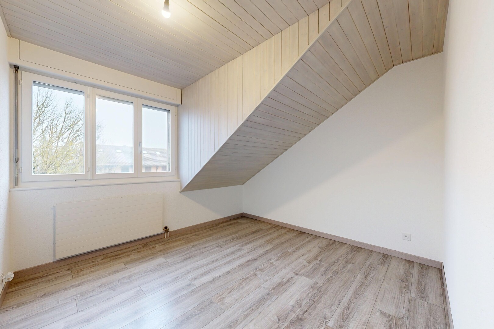 pièce vide avec radiateur, inside property, natural light, lumière naturelle, et wood finish floor