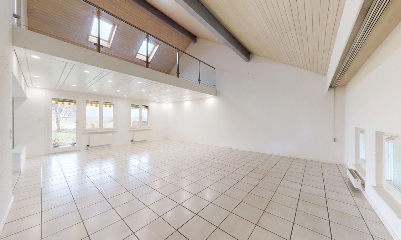 pièce vide avec high ceiling, plafond haut, natural light, lumière naturelle, et beamed ceiling