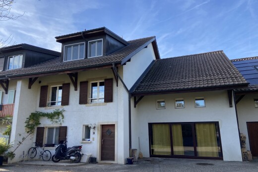 façade avec toit mansardé, bardage en stuc, day time, garage, et property visible