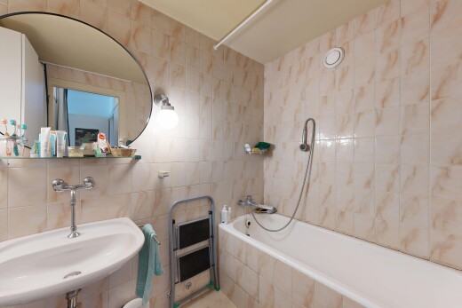 salle de bains avec tile wall, mur en carrelage, miroir, évier, et douche-bain combinés