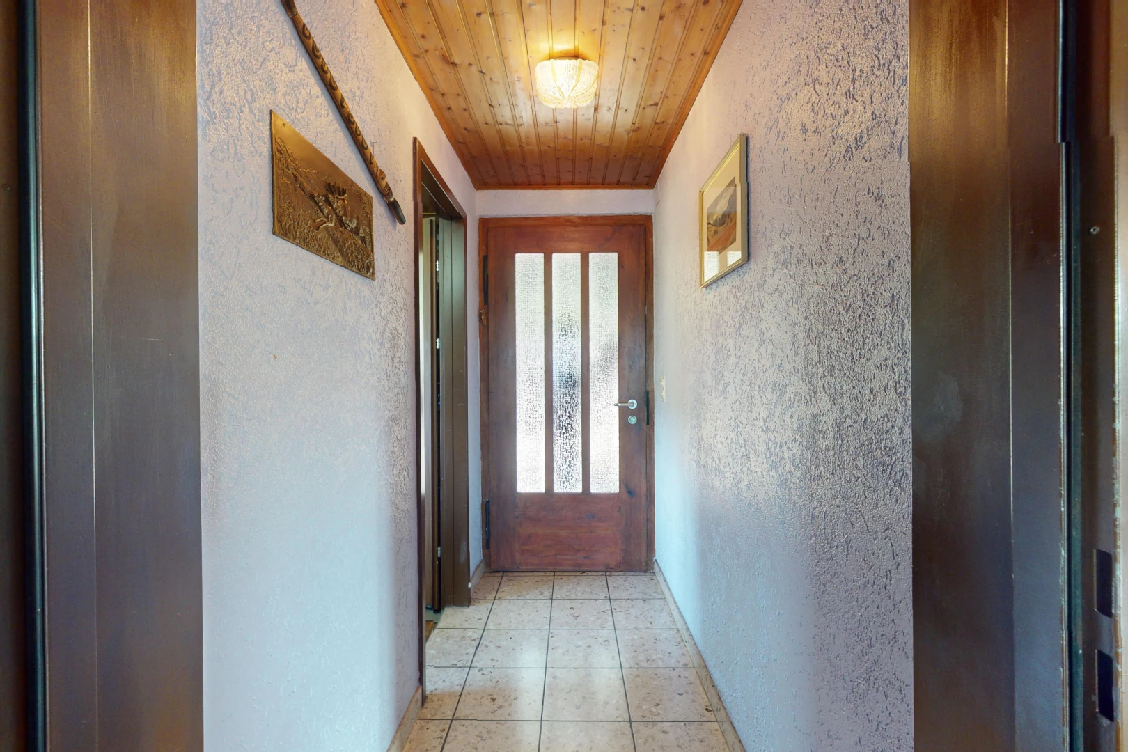 couloir avec carrelage, plafond de bois, et lumière naturelle