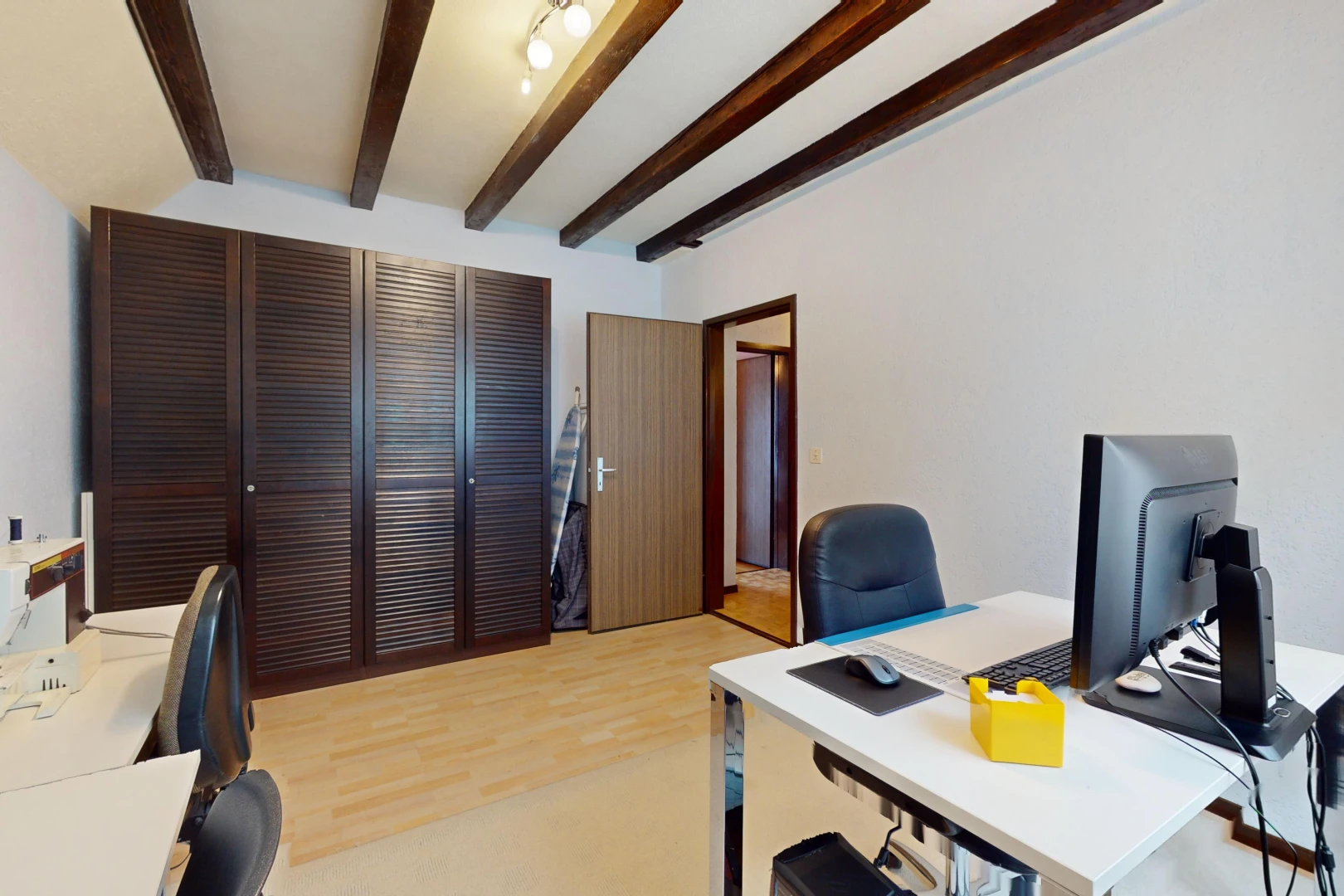 bureau avec poutres apparentes, plancher de bois, et télévision