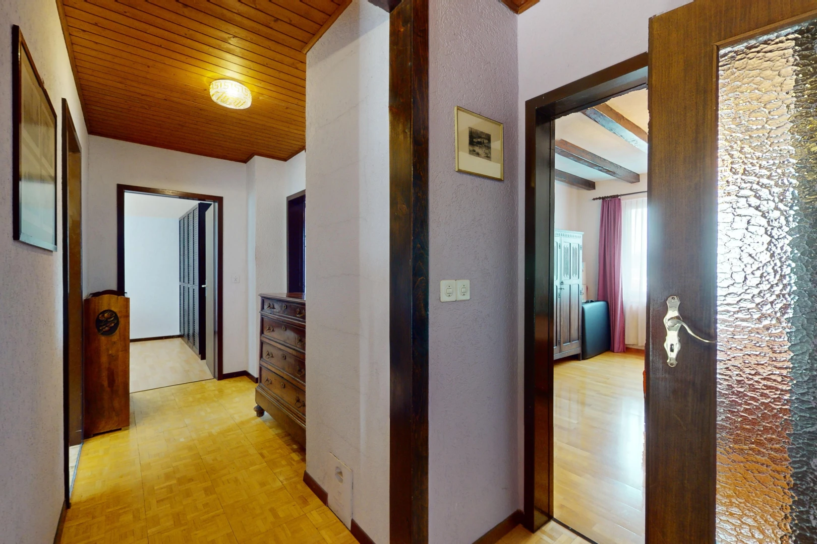 couloir avec poutres apparentes, lumière naturelle, et plafond de bois