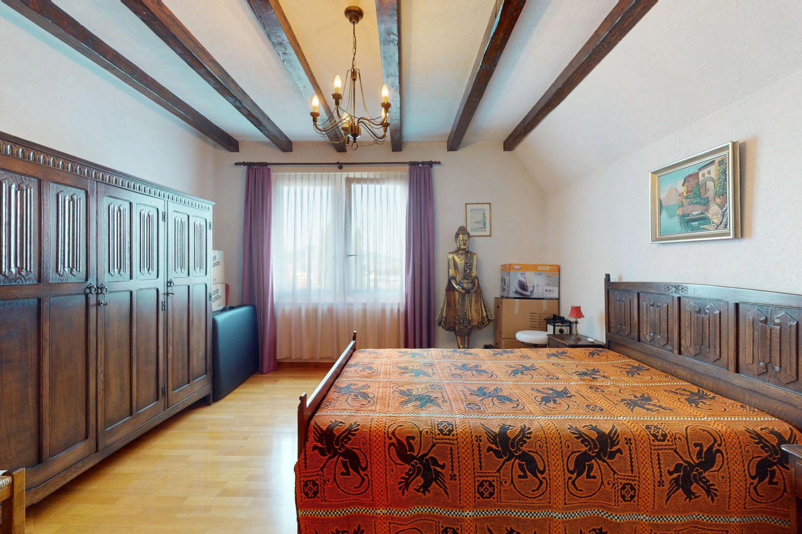 chambre avec lustre, plancher de bois, poutres apparentes, lumière naturelle, et plafond voûté
