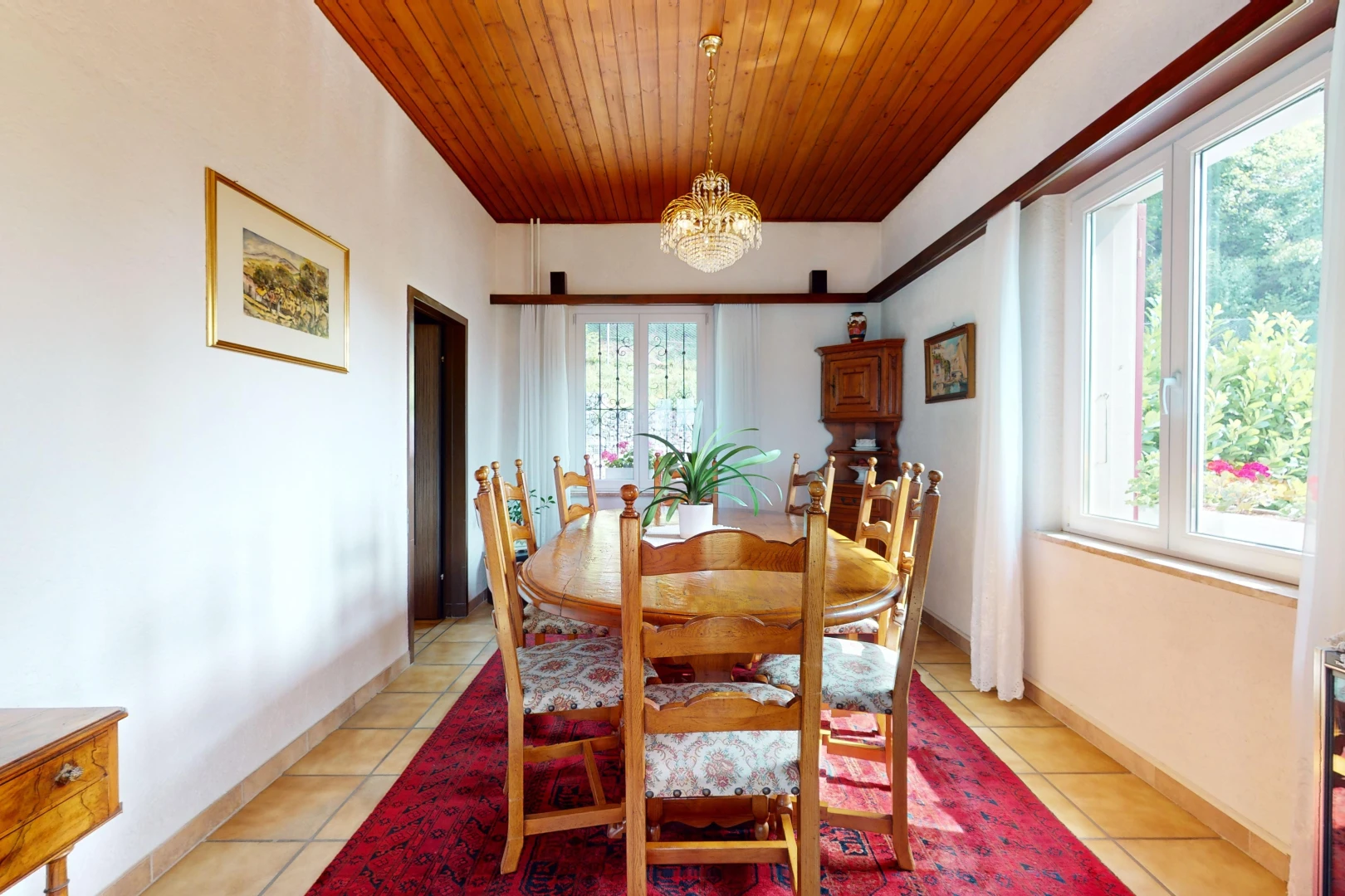 salle à manger avec plafond de bois, lumière naturelle, lustre, et carrelage