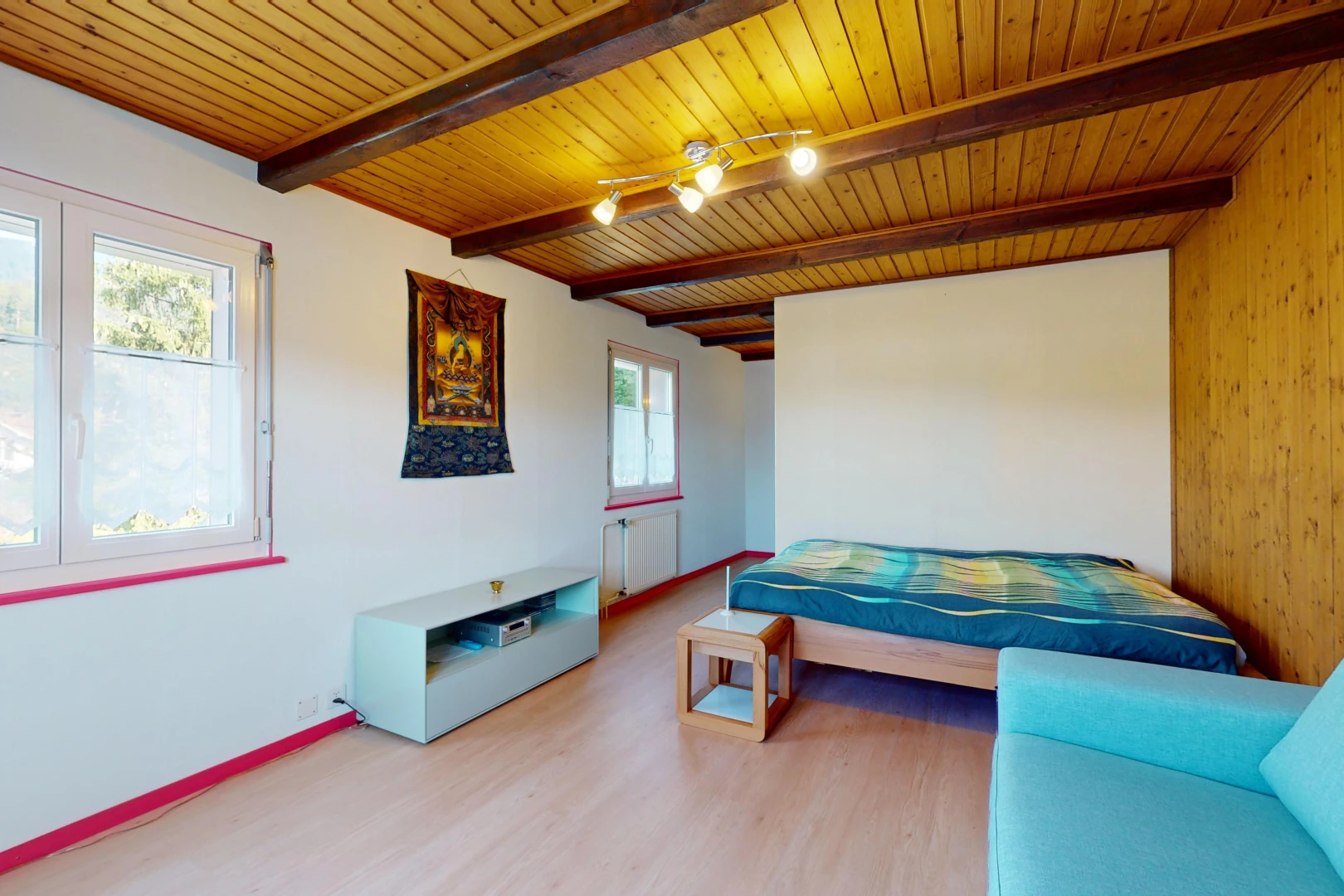 chambre avec radiateur, poutres apparentes, plafond de bois, et lumière naturelle