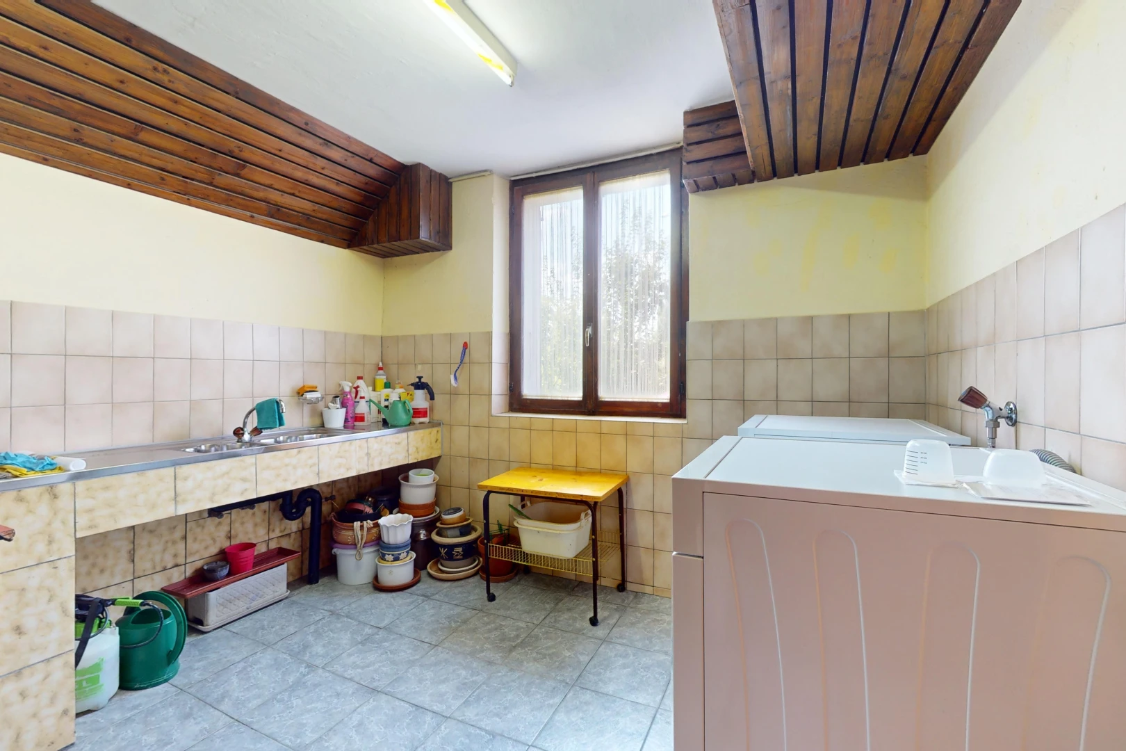 espace intérieur avec mur carrelé, carrelage, baignoire, et lumière naturelle