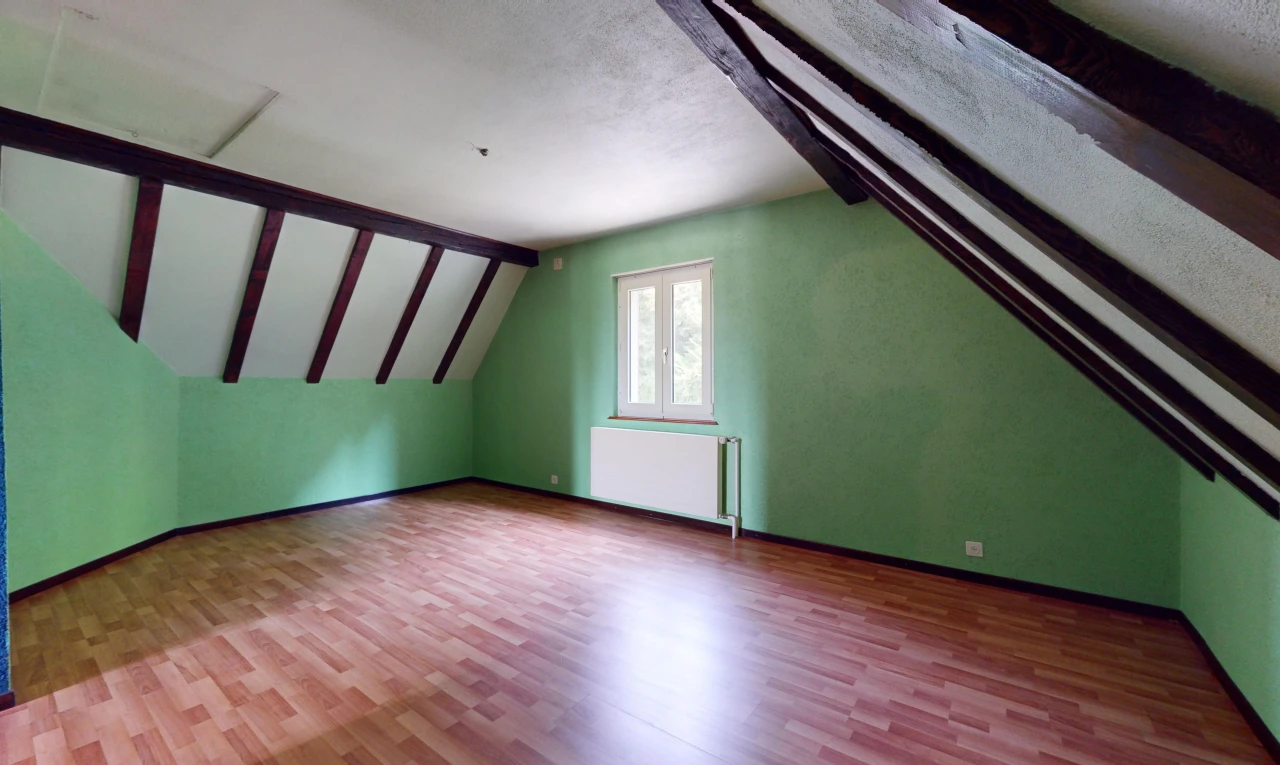 pièce vide avec plafond voûté, lumière naturelle, plafond en crépis, plancher de bois, et radiateur