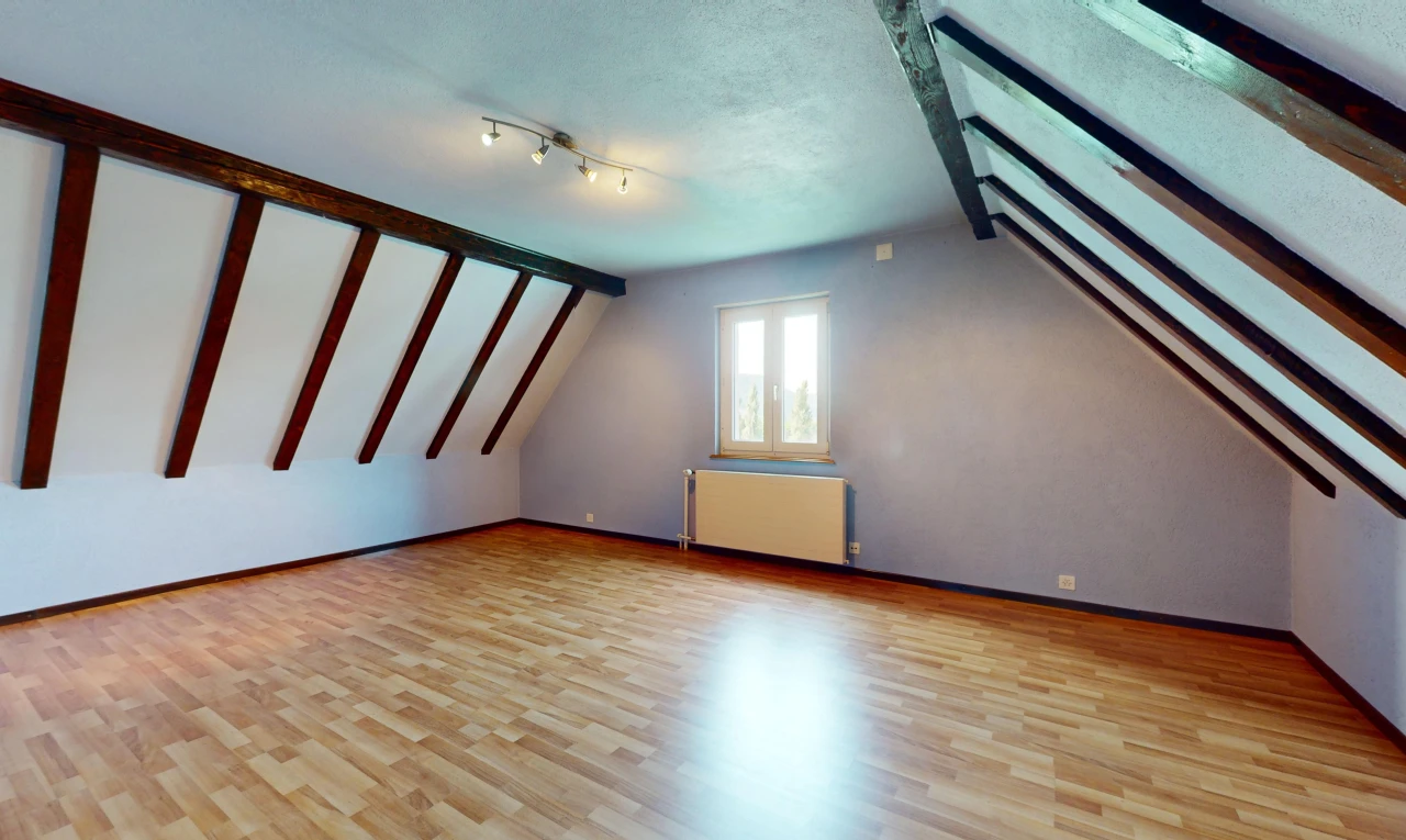pièce vide avec radiateur, plancher de bois, et lumière naturelle